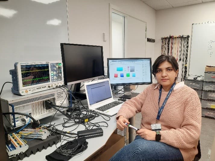Zahra Tajalli at a laboratory bench with an oscilloscope and test equipment