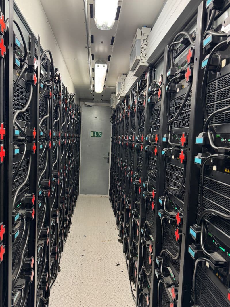 Row of battery cabinets inside a containerized energy storage system